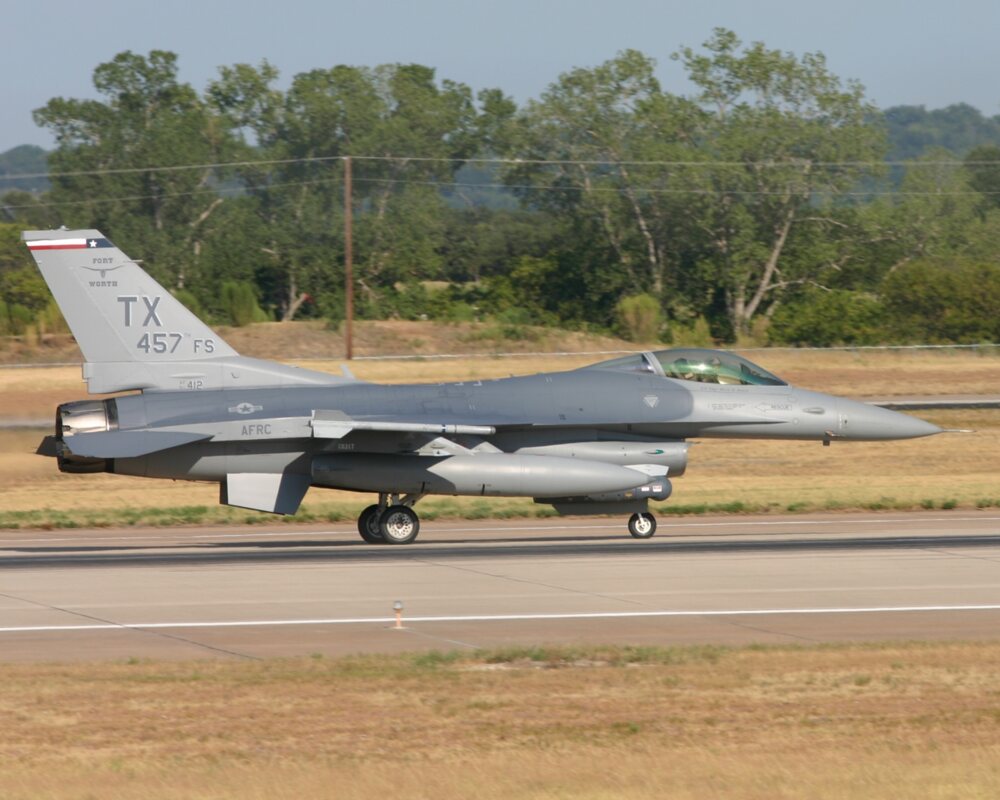 Gray F-16 fighter jet taxiing, with TX on the tail