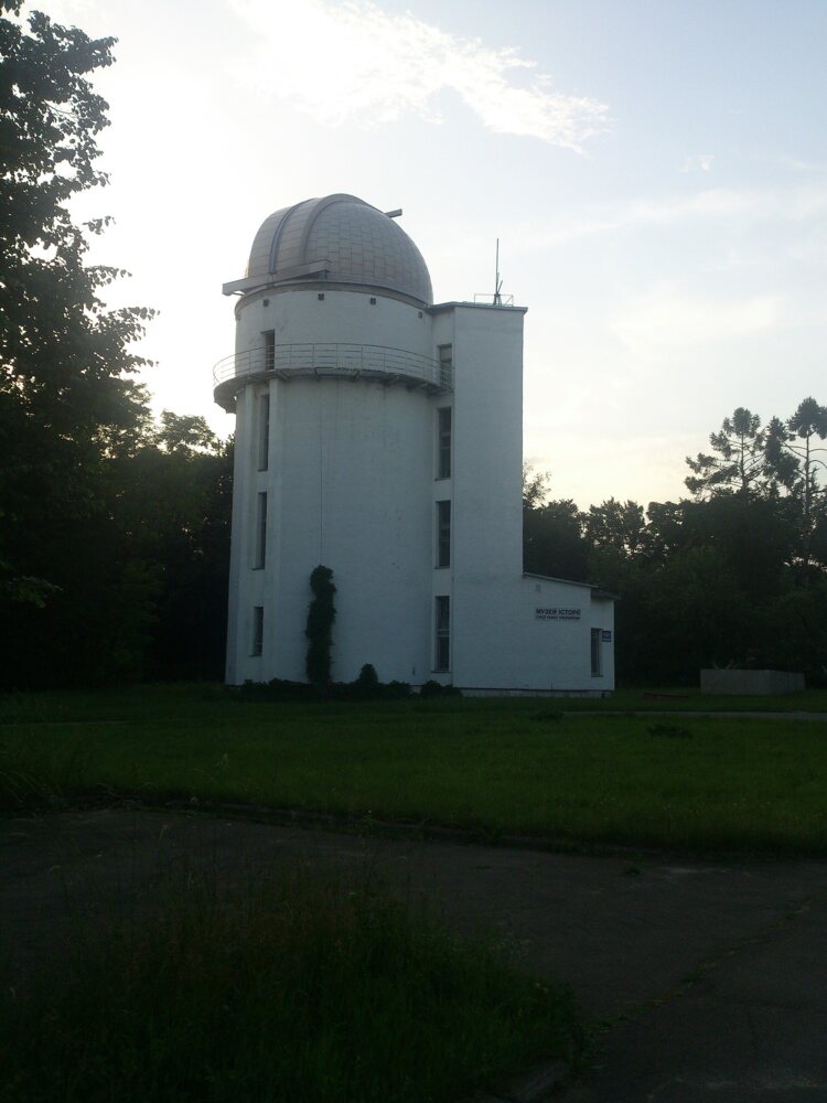 White tower with an observatory dome among trees