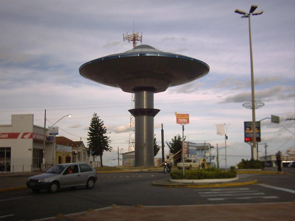 Flying-saucer-shaped water tower at a traffic circle, by day
